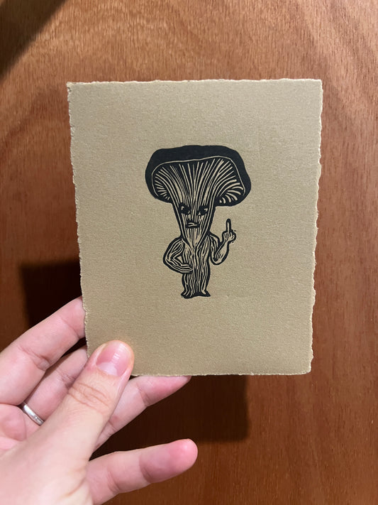 Handmade mini linocut print of a Fungarian creature in black ink on kraft brown Stonehenge paper
