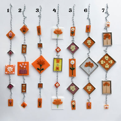 Handmade stained glass suncatcher chain with real pressed flowers in orange tones